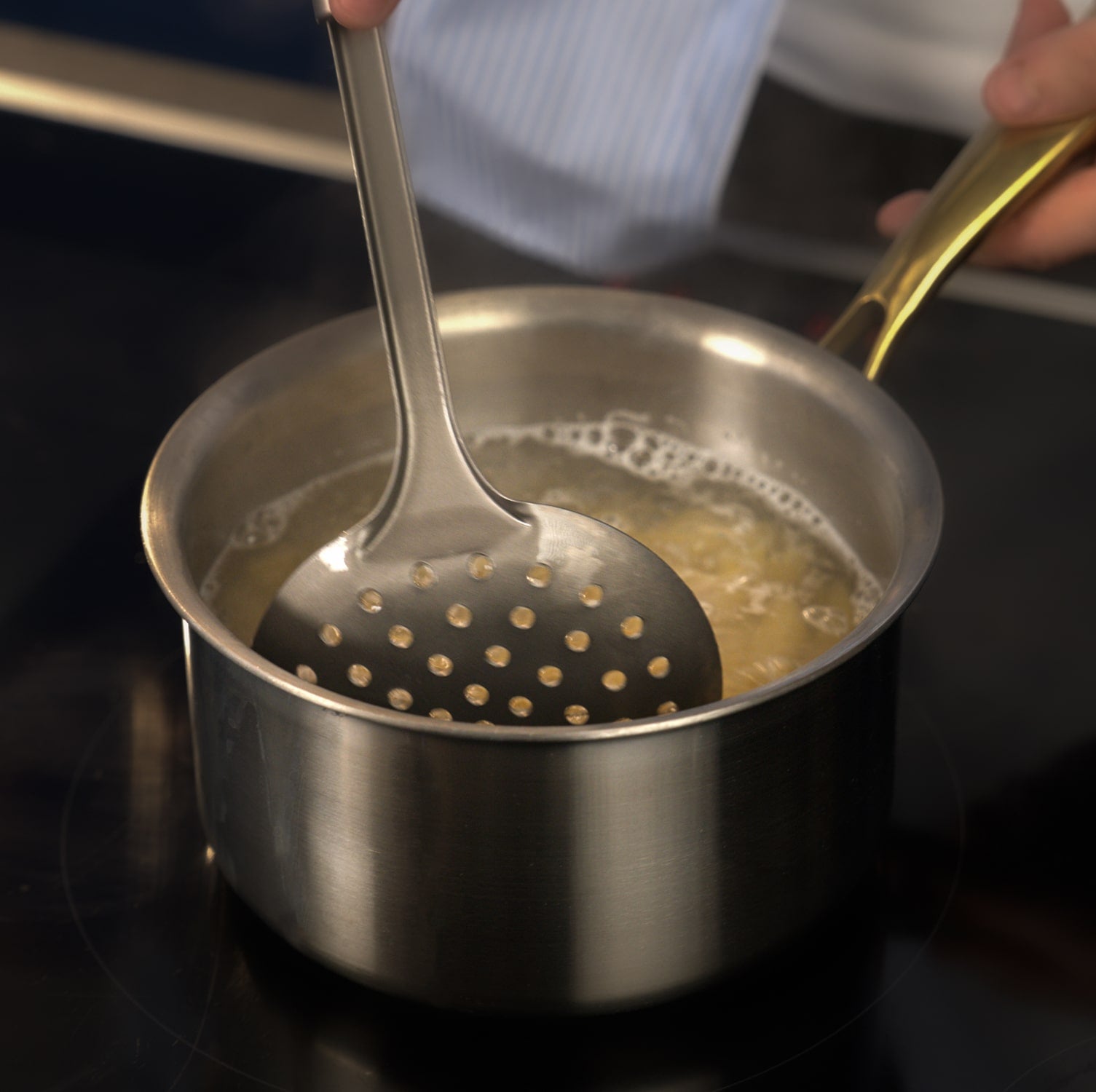 Stirring a pot of boiling liquid with titanium utensils