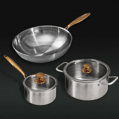 Set of titanium cookware with gold handles on a black background